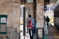 Brescia, Italy.Black man walking alone on a train platform with a red backpack Royalty Free Stock Photo