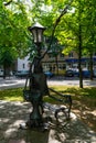 Brest, Belarus - April 2022: Lantern in the form of a sculpture of a tailor with a bench in the city park