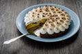 Breton cake with plums and meringue on a wooden table