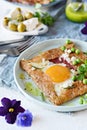 Breton traditional pancake made from buckwheat flour with ham, cheese, egg, feta, green peas and green butter.