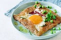 Breton traditional pancake made from buckwheat flour with ham, cheese, egg, feta, green peas and green butter.