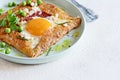Breton traditional pancake made from buckwheat flour with ham, cheese, egg, feta, green peas and green butter.