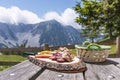 Brettljause on wooden table with view to mountain range Karawanks