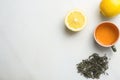 Brewed Green Tea in Ceramic Cup. Loose Leaves Scattered on White Marble Stone Background Slice of Lemon. Chinese Japanese Royalty Free Stock Photo