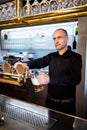 Brewer filling beer in beer glass from beer pump Royalty Free Stock Photo