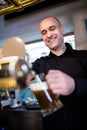 Brewer filling beer in beer glass from beer pump Royalty Free Stock Photo