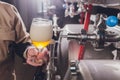 Brewer man and apron pours beer in a glass for quality control, standing behind the counter in a brewery. Royalty Free Stock Photo