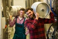 Brewers carrying keg on shoulder