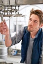 Brewery, man and pipe in factory with manufacturing for craft beer, alcohol and production process in machine Royalty Free Stock Photo