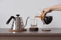 Brewing coffee in hand drip coffee maker. Woman hand pour coffee