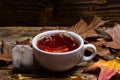 Brewing tea concept. Cup pouring with water or tea with splashes on dark wooden background. Mug pouring with liquid with