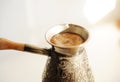 Brewing turkish coffee in cooper cezve close up. White background Royalty Free Stock Photo