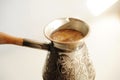 Brewing turkish coffee in cooper cezve close up. White background Royalty Free Stock Photo