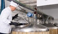 Brewmaster opening lid of fermenter while checking beer production process