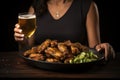 Brews Wings Bliss: Savoring the bliss of brews and wings, a woman relishes the combination of beer refreshment and