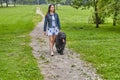 Briard and woman are walking in patk at summer.