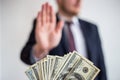 Bribe and corruption,offered cash to a businessman in a suit, does not want to take them, hold upright hands Royalty Free Stock Photo