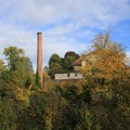 Brich chimney, old factory Schoenau surrounded by colorful trees