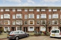 a brick apartment building with cars parked in front