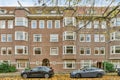 a brick apartment building with two cars parked outside