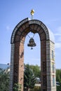 A brick arch with a bell and a spire near the Temple of All Religions in Kazan, Russia Royalty Free Stock Photo