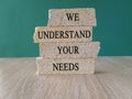 Brick blocks with WE UNDERSTAND YOUR NEEDS text on beautiful green background. Client relationship and marketing strategy concept Royalty Free Stock Photo