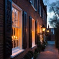 A brick building with black shutters and windows lit up with candles Royalty Free Stock Photo