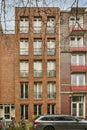 a brick building with many windows and a car parked Royalty Free Stock Photo