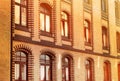 A brick building with shiny windows at sunset, beautiful sunlight reflected from the glass, the old architecture Royalty Free Stock Photo
