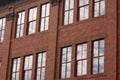 Brick building with windows reflecting clouds and sky Royalty Free Stock Photo