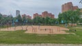 Among the brick buildings of the urban area is a sports field with a sandy surface, benches, metal simulators and with wooden bask Royalty Free Stock Photo
