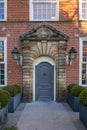 A brick-built house facade with a stone-made carriage porch