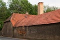 Brick chimney red roof old building with damaged brick wall. Royalty Free Stock Photo