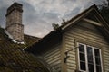 Brick chimney and roof in an old abandoned house against the background of a sky with clouds Royalty Free Stock Photo