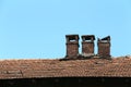 Brick chimney on tile roof of an old wooden house