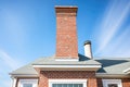 brick chimney on a white cape cod house