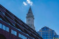 A BRICK CLOCK TOWER WITH A BRICK BUILDING IN FRONT AND A MODERN GLASS COVERED BUILDING Royalty Free Stock Photo