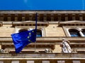 Exterior facade with EU flag half folded under blue sky