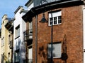 Brick facade of classical residential apartment building with wrought iron balcony. retro style street lamps Royalty Free Stock Photo