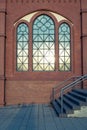 A brick facade with ornate windows that reflect the setting sun