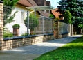 Brick fence post or pier. ceramic capping. wire mesh grille fence panels. lush green grass Royalty Free Stock Photo