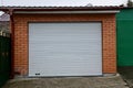 Brick garage facade with white gates on the street