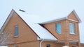 Brick house building covered snow with attic and frozen rain gutter Royalty Free Stock Photo