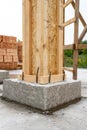 Brick house construction concept. Close up vertical photo of building support element with wooden column and concrete formwork