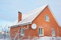 Brick house with metal roof covered snow after night snowstorm Royalty Free Stock Photo