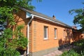 Cozy brick house with old asbestos roof. Rain gutter and brick wall. Royalty Free Stock Photo