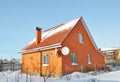 Brick House with red metal roof tile and chimney covered snow in winter Royalty Free Stock Photo