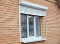 Brick house window with rolling shutter for home protection