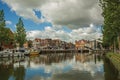 Brick houses, moored boats and bascule bridge reflected in wide canal water surface on sunset in Weesp.