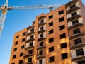 Brick multistory building under construction with crane on the site, bottom view Royalty Free Stock Photo